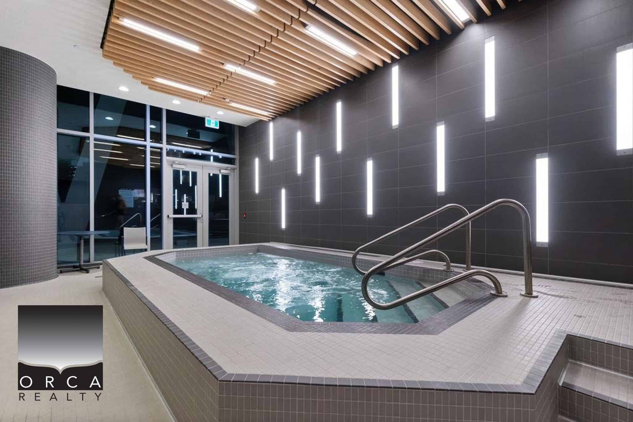 Luxurious indoor hot tub with modern lighting and sleek design, perfect for relaxation at Orca Realty Inc. property showcase.