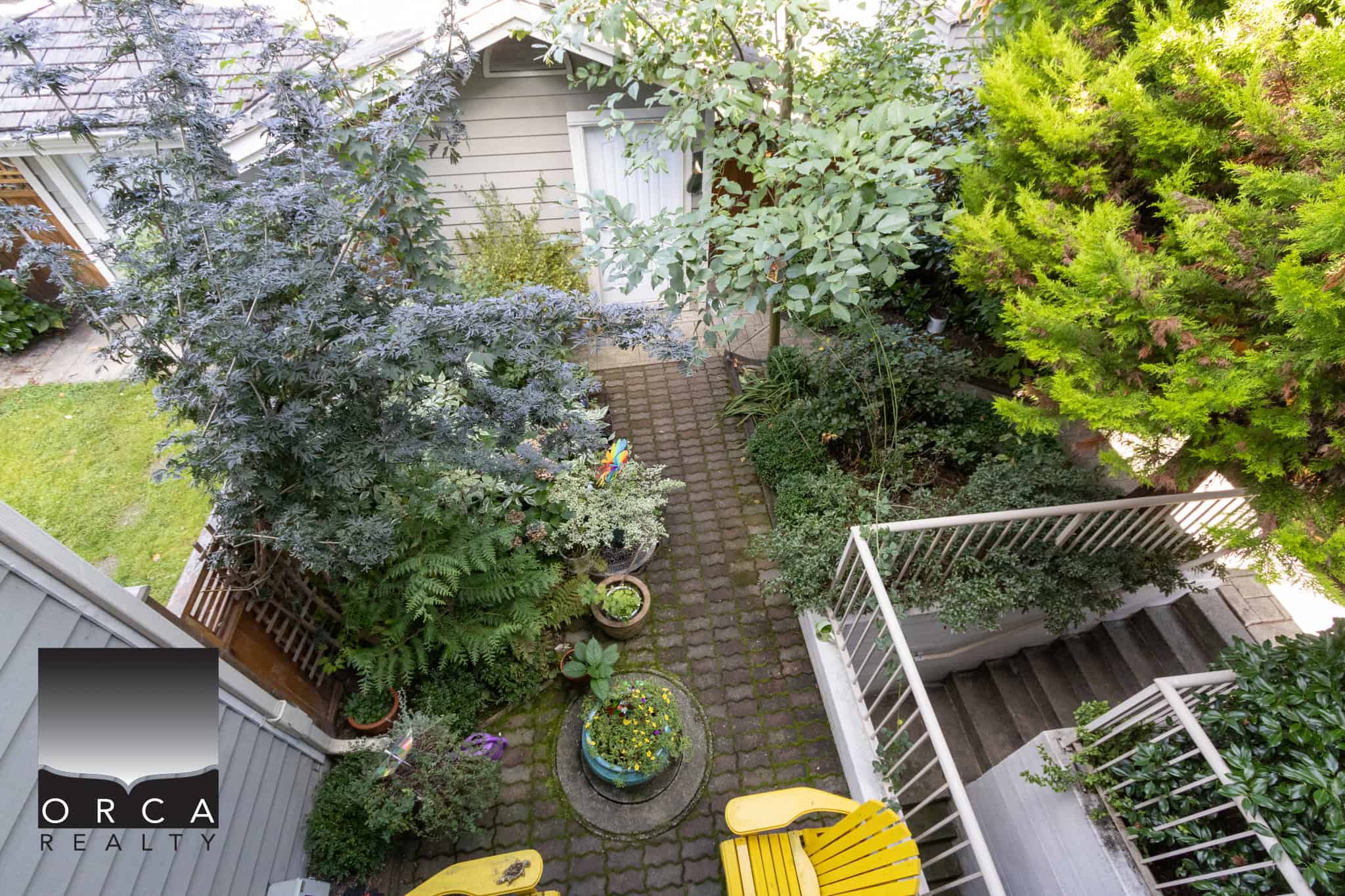 23 Lush backyard garden with vibrant plants and trees, cozy patio area, and decorative flower pots, perfect for outdoor relaxation and entertaining in Vancouver homes.