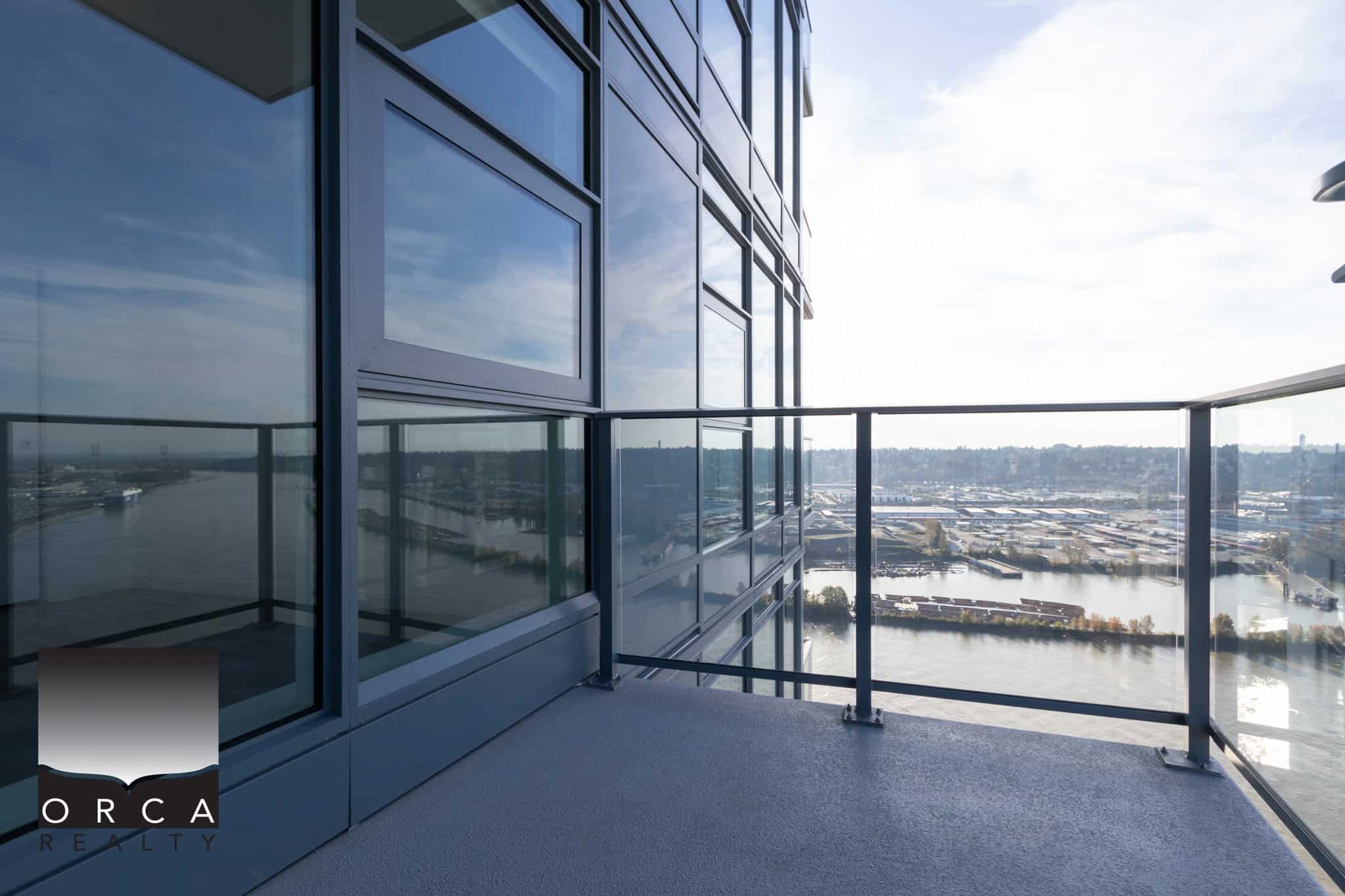 23 Stunning city view from a modern high-rise balcony featuring sleek glass railings and contemporary architecture, ideal for luxury real estate in Vancouver.