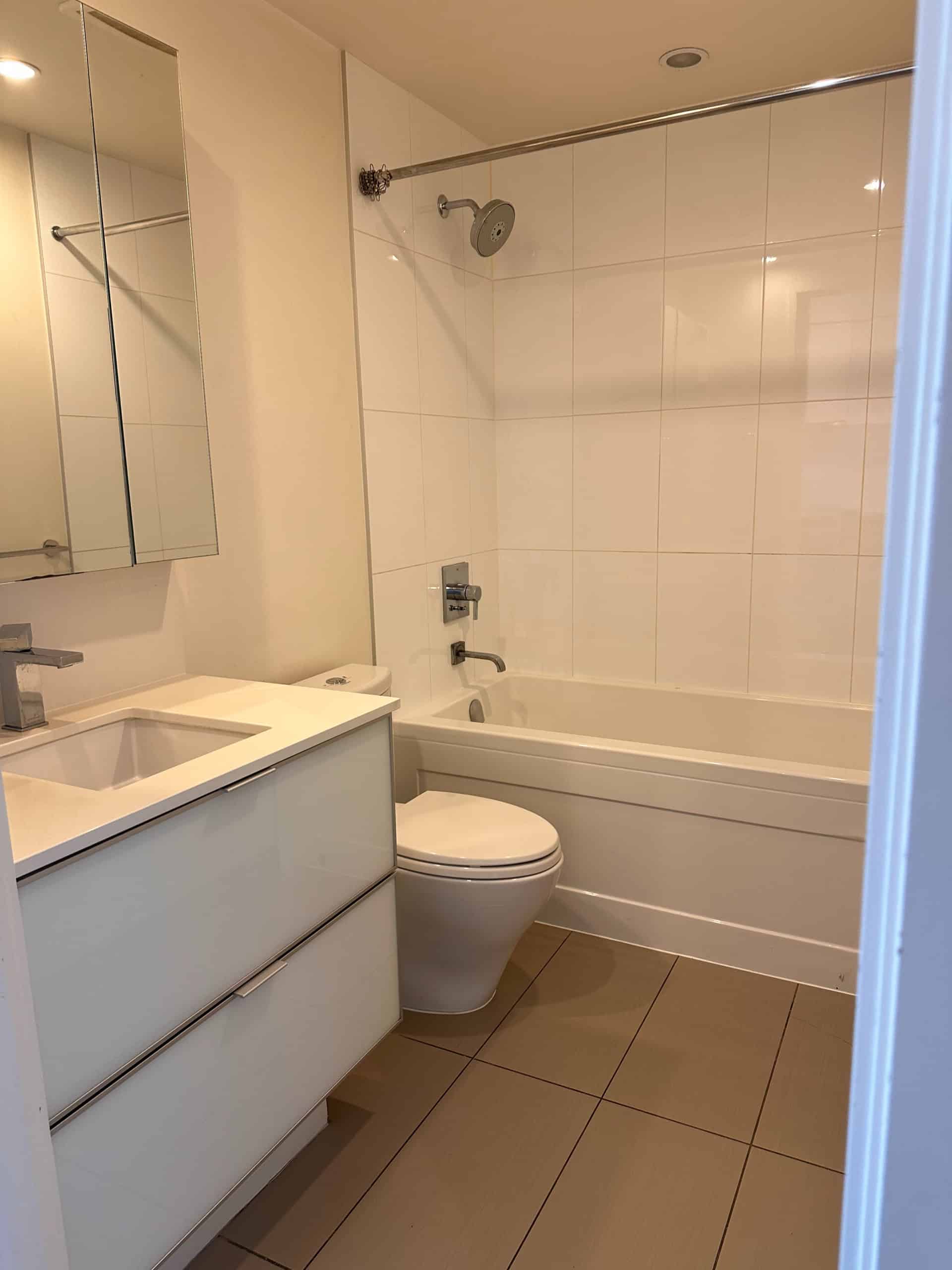 Modern bathroom with bathtub, shower, and sleek vanity in a contemporary residential property. Perfect for comfortable living in the Vancouver area.
