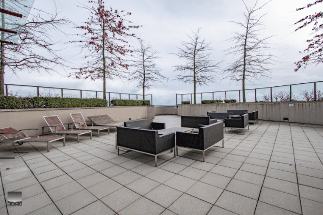 Modern outdoor rooftop patio with lounge chairs and seating area, perfect for relaxing and entertaining in Vancouver. Overlooking city views, ideal for real estate property showcasing.