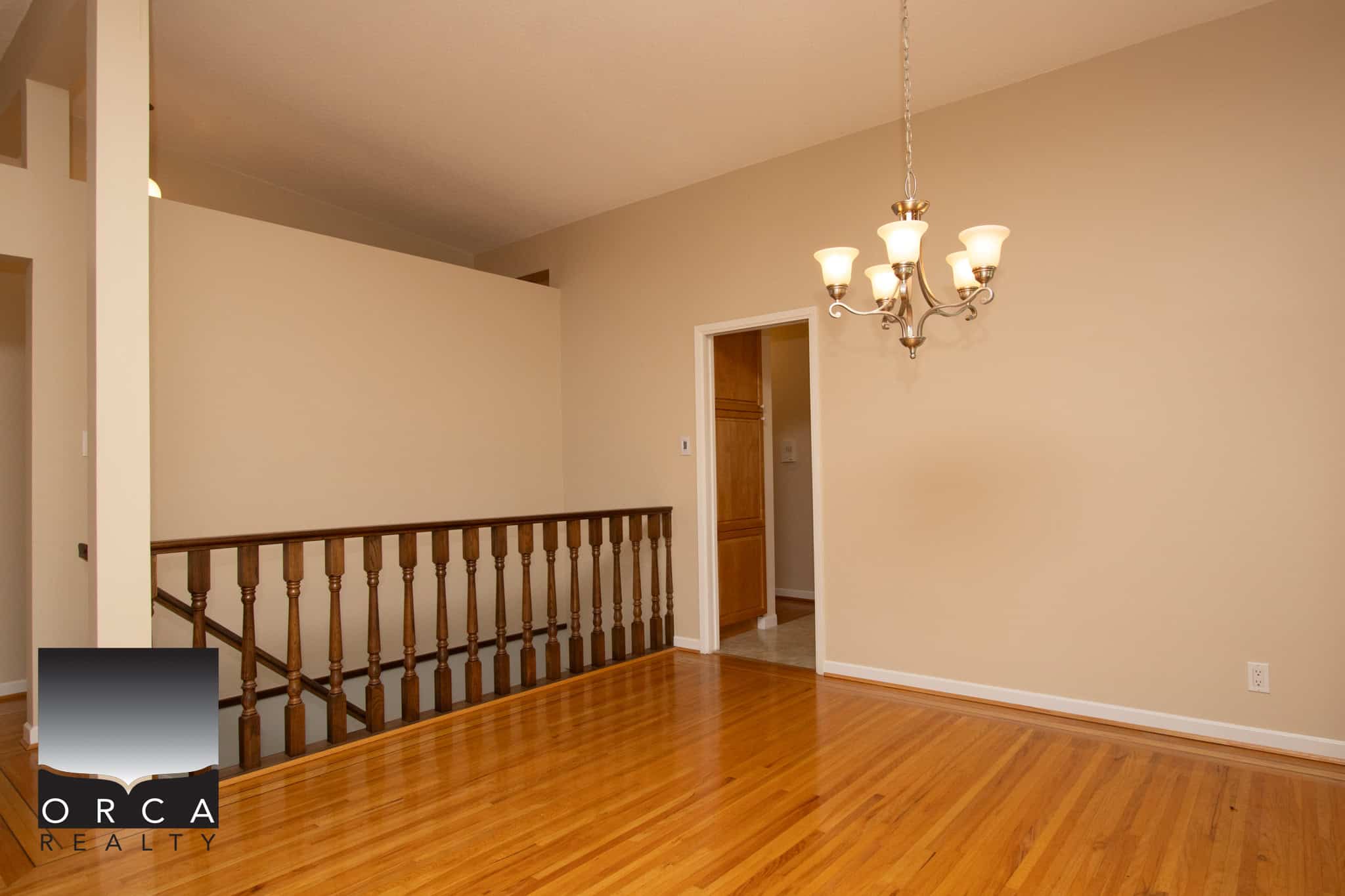 Bright interior of a modern home with hardwood flooring, a chandelier, and neutral wall colors in Vancouver, BC, showcasing elegant home decor and spacious living area.