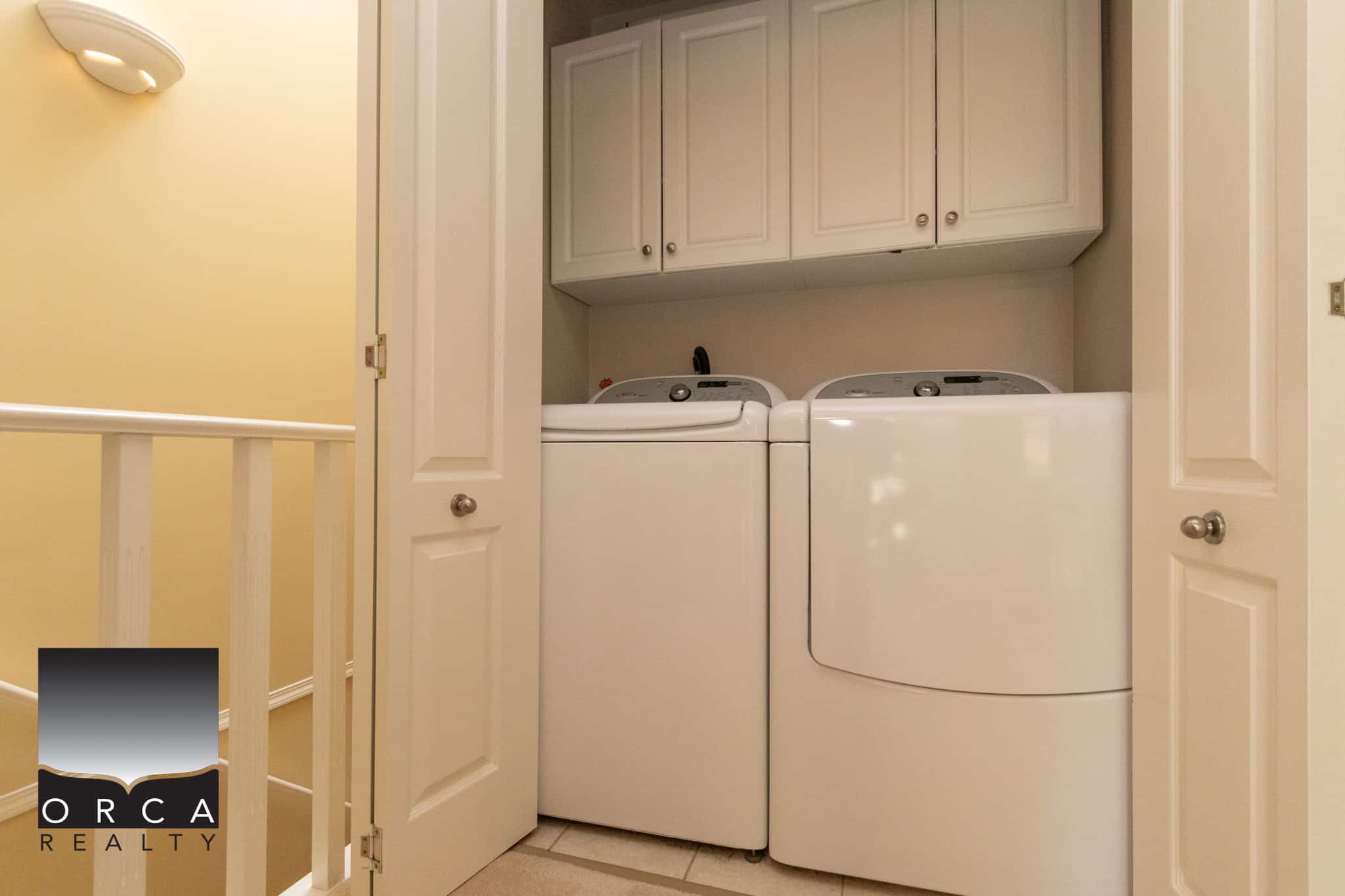 24 Clean white washer and dryer in a dedicated laundry closet with white cabinetry, perfect for modern home living in Ontario.