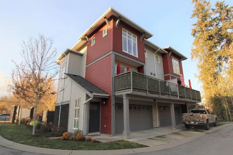 New modern multi-level residential home with garage, outdoor balcony, and contemporary architecture in a scenic neighbourhood in Victoria, BC.