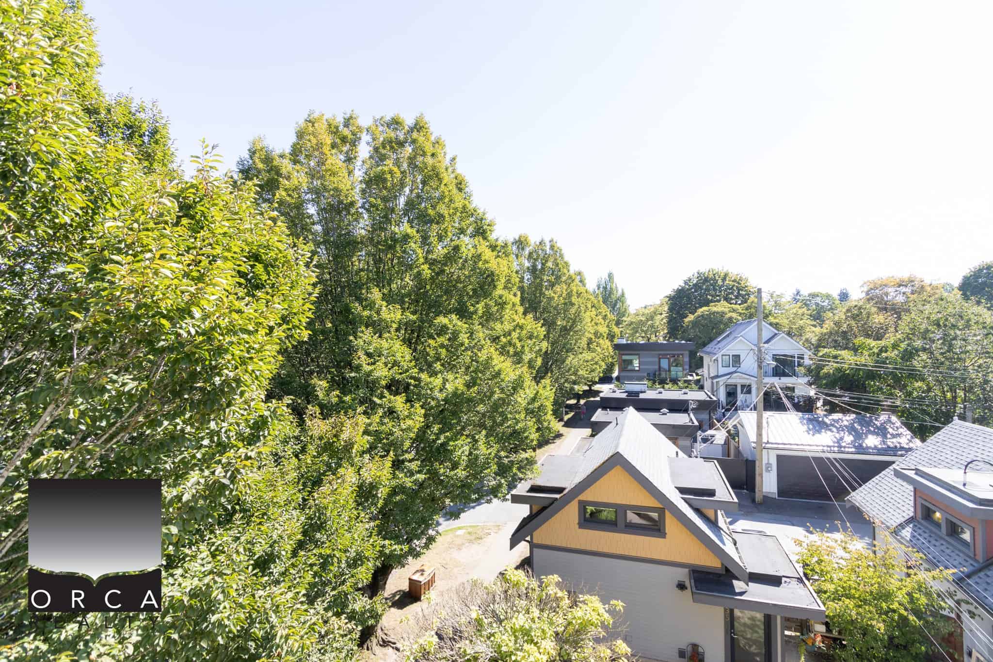 Vibrant neighbourhood with lush green trees and charming houses in Victoria, BC, showcasing desirable real estate options.