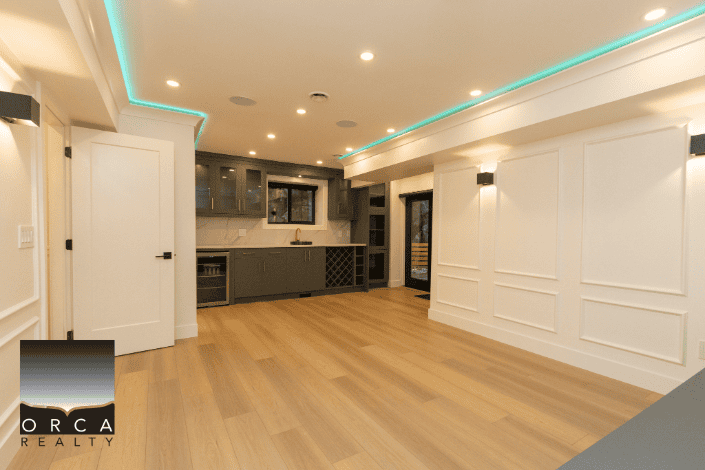 Bright, modern kitchen and living space with sleek cabinetry, hardwood flooring, and ambient LED lighting, perfect for Vancouver real estate buyers seeking stylish homes.