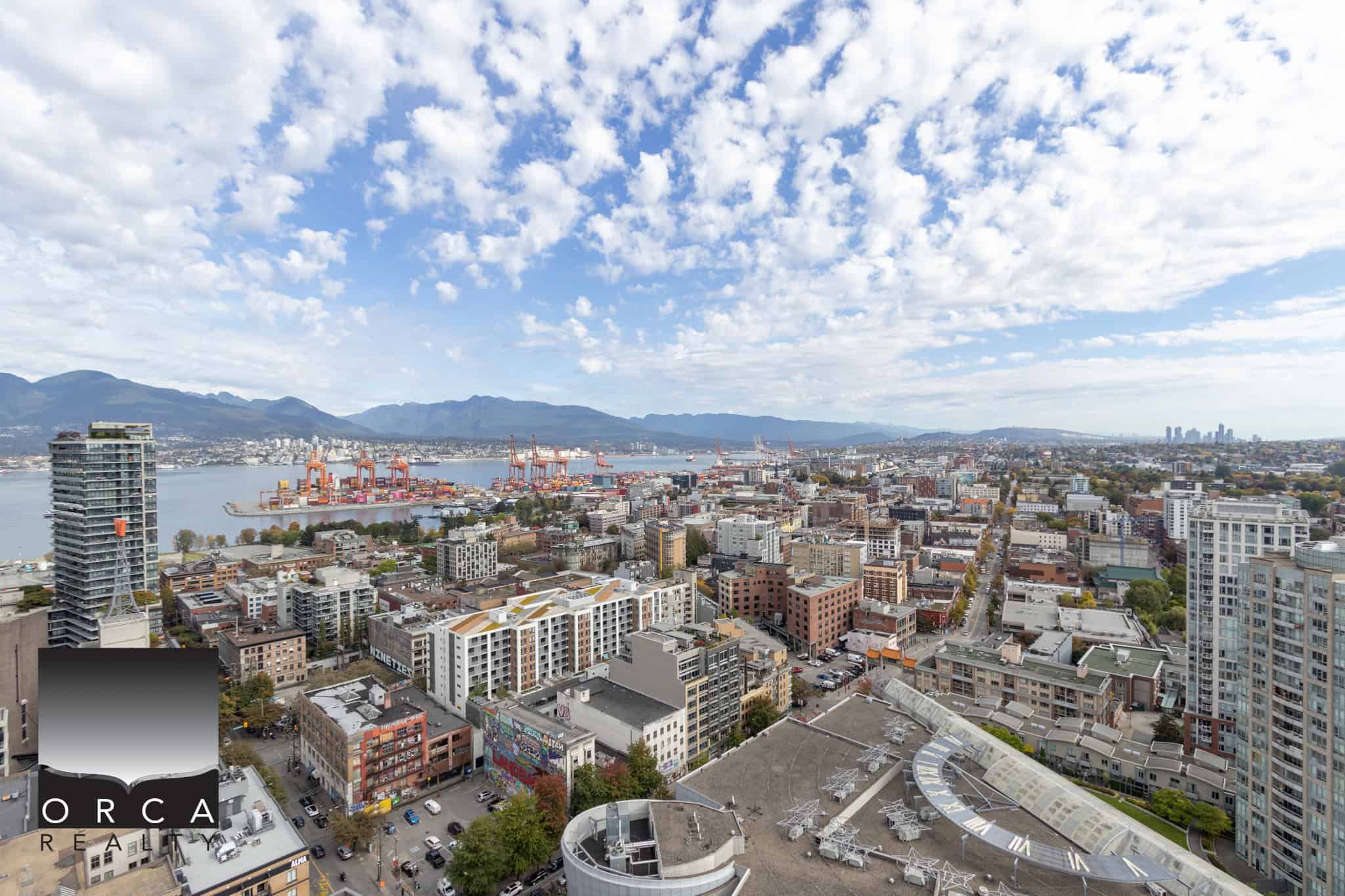 26 Breathtaking Vancouver skyline with waterfront views, modern high-rise apartments, and mountain backdrop, showcasing Vancouver real estate opportunities and urban living in British Columbia.