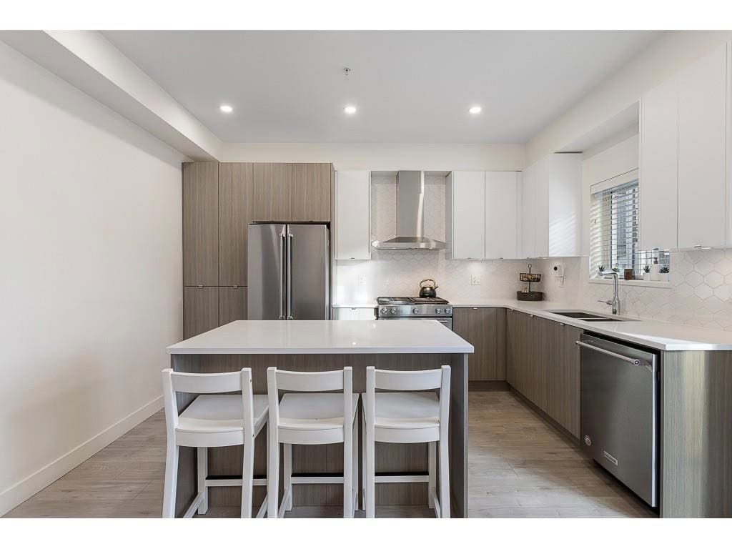 Bright modern kitchen with white cabinets, stainless steel appliances, and a central island, perfect for family living and entertaining in Vancouver's real estate market.