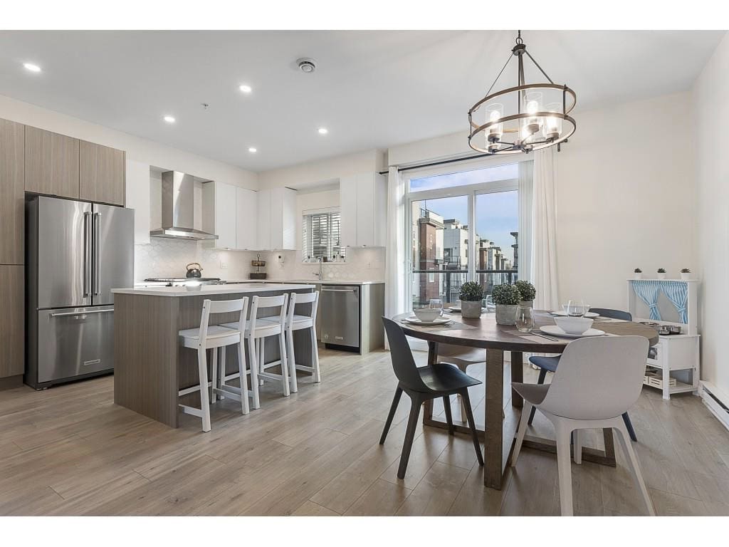 Modern open-concept kitchen and dining area with stainless steel appliances, minimalist design, and natural light in a contemporary Vancouver home.
