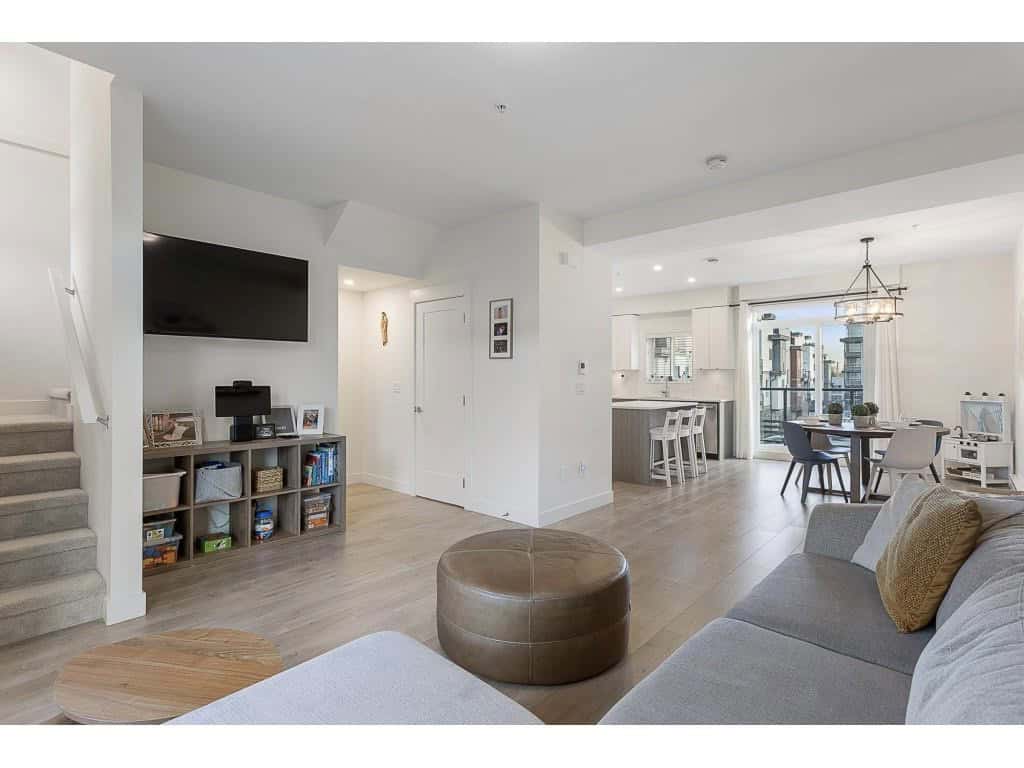 Modern open-concept living room and kitchen in downtown Vancouver, showcasing stylish interior design and city skyline views, ideal for Vancouver real estate buyers.