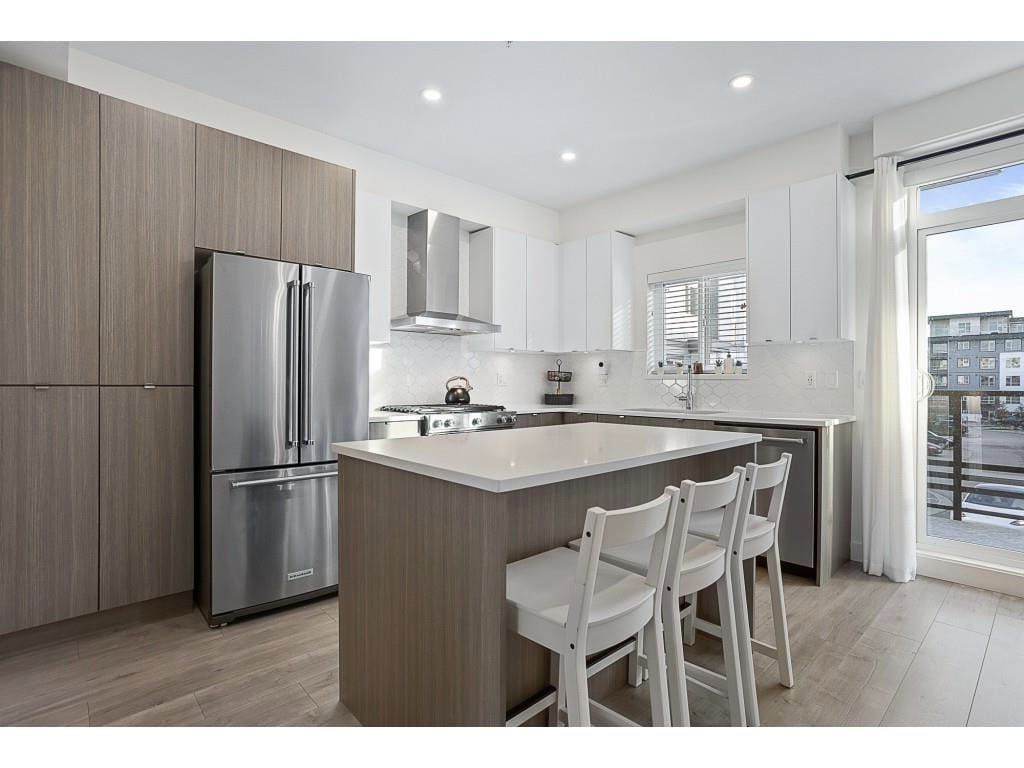 Contemporary kitchen with stainless steel appliances, white cabinetry, and natural lighting in a modern apartment. Perfect for Vancouver real estate and property showcasing.