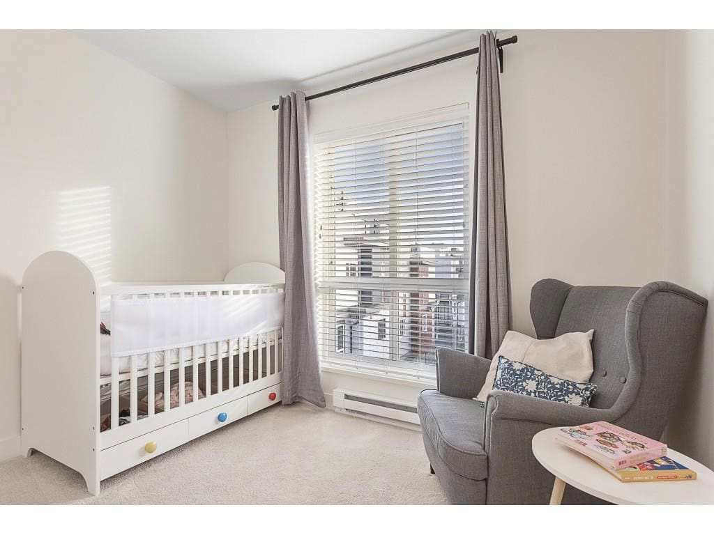 Bright nursery room with crib, armchair, and large window with blinds in a modern home. Ideal for families seeking a comfortable, stylish living space. Perfect for real estate listings and home interior showcases.