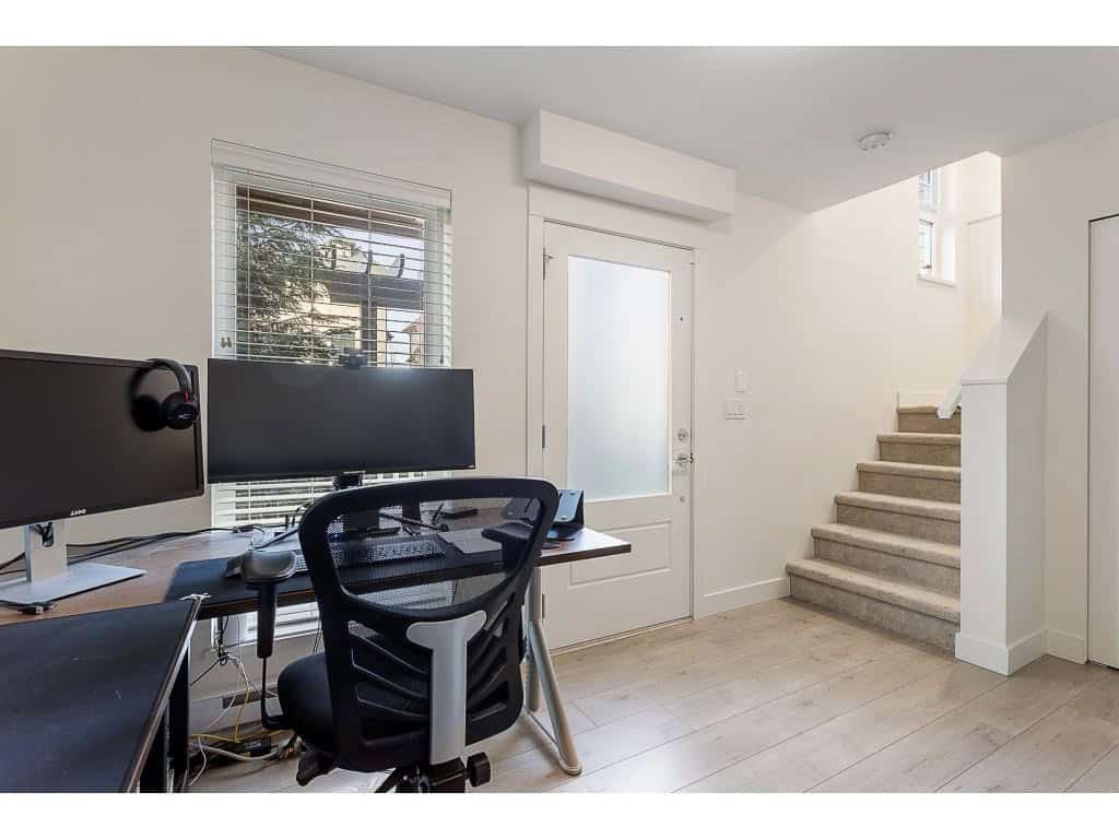 Modern home office with dual monitors and ergonomic chair in a bright, minimalist interior.