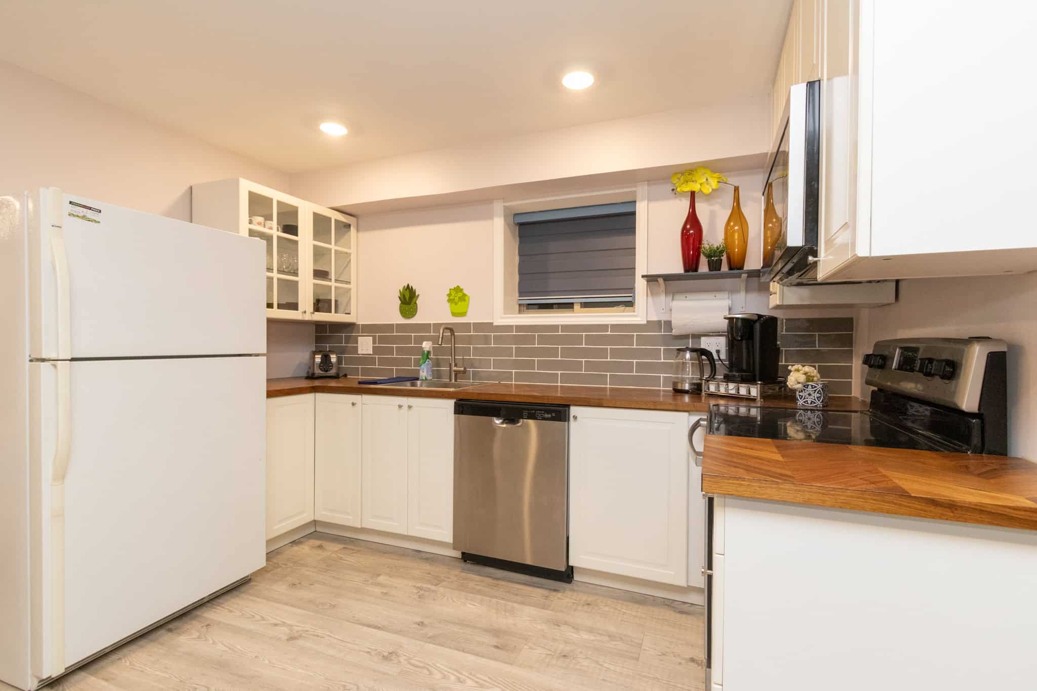 28 Bright modern kitchen with white cabinetry, stainless steel appliances, and grey subway tile backsplash, ideal for comfortable home living and entertaining.