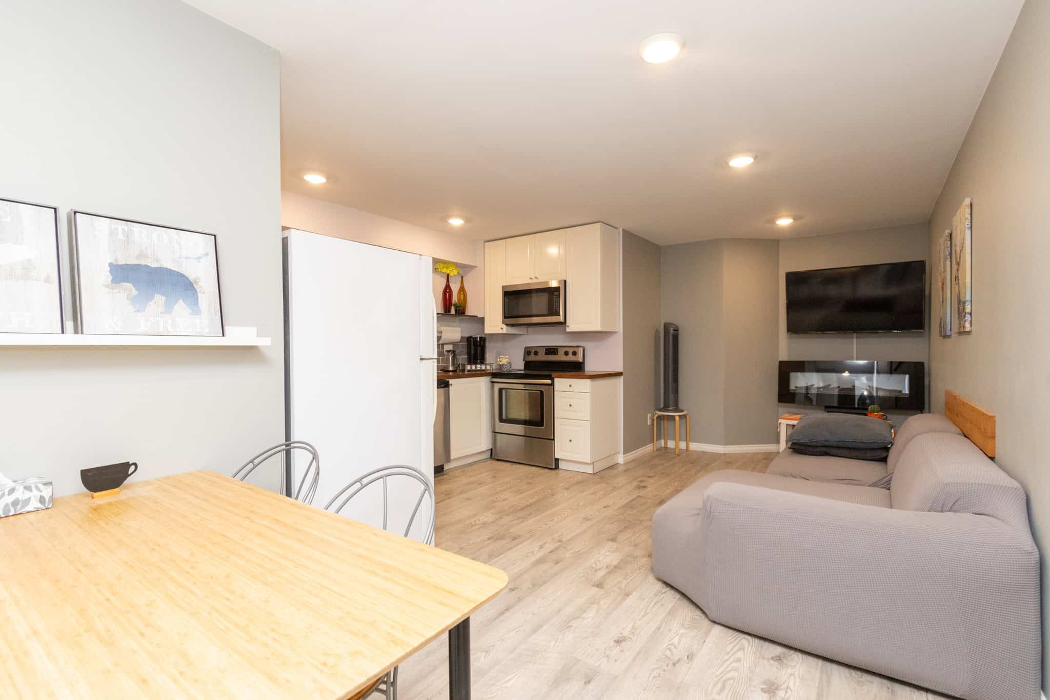 29 Modern open-concept living room and kitchen in a Vancouver property listed by Orca Realty Inc., featuring contemporary furnishings, hardwood flooring, and essential appliances.