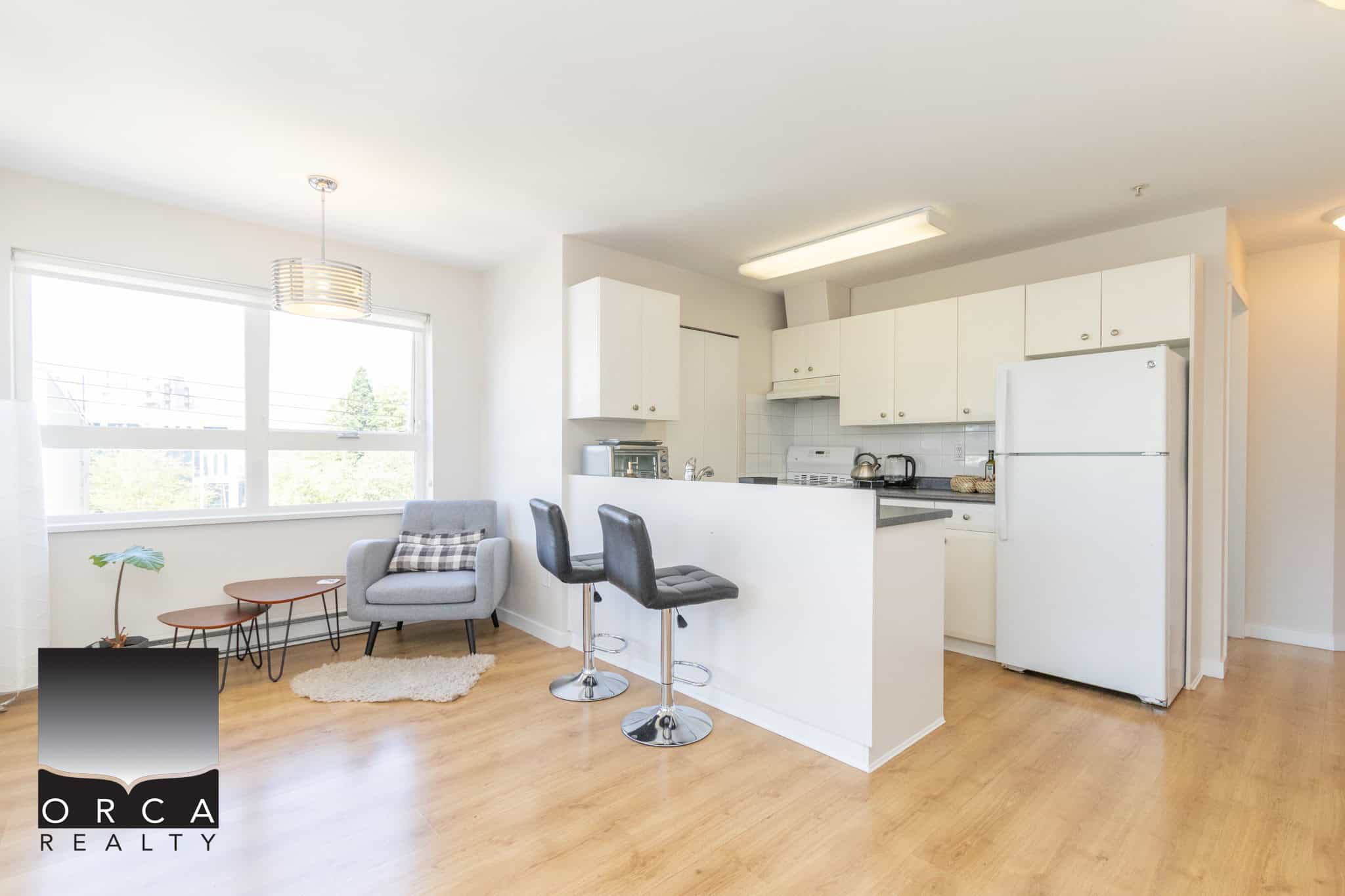 Bright and modern Vancouver apartment with open-concept kitchen, stylish furnishings, and large windows offering natural light, perfect for comfortable city living.