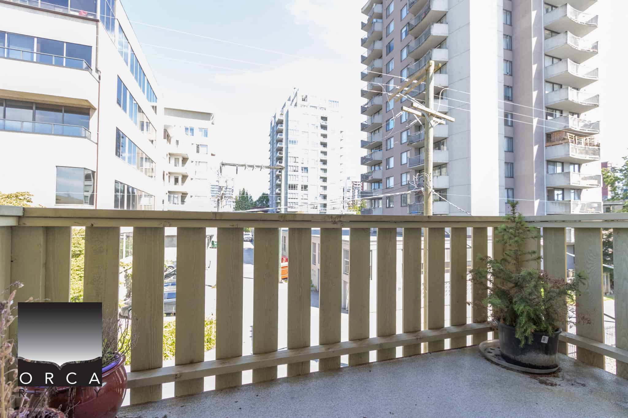 Modern balcony view of high-rise apartment buildings in Vancouver, showcasing urban living and real estate opportunities with Orca Realty Inc.