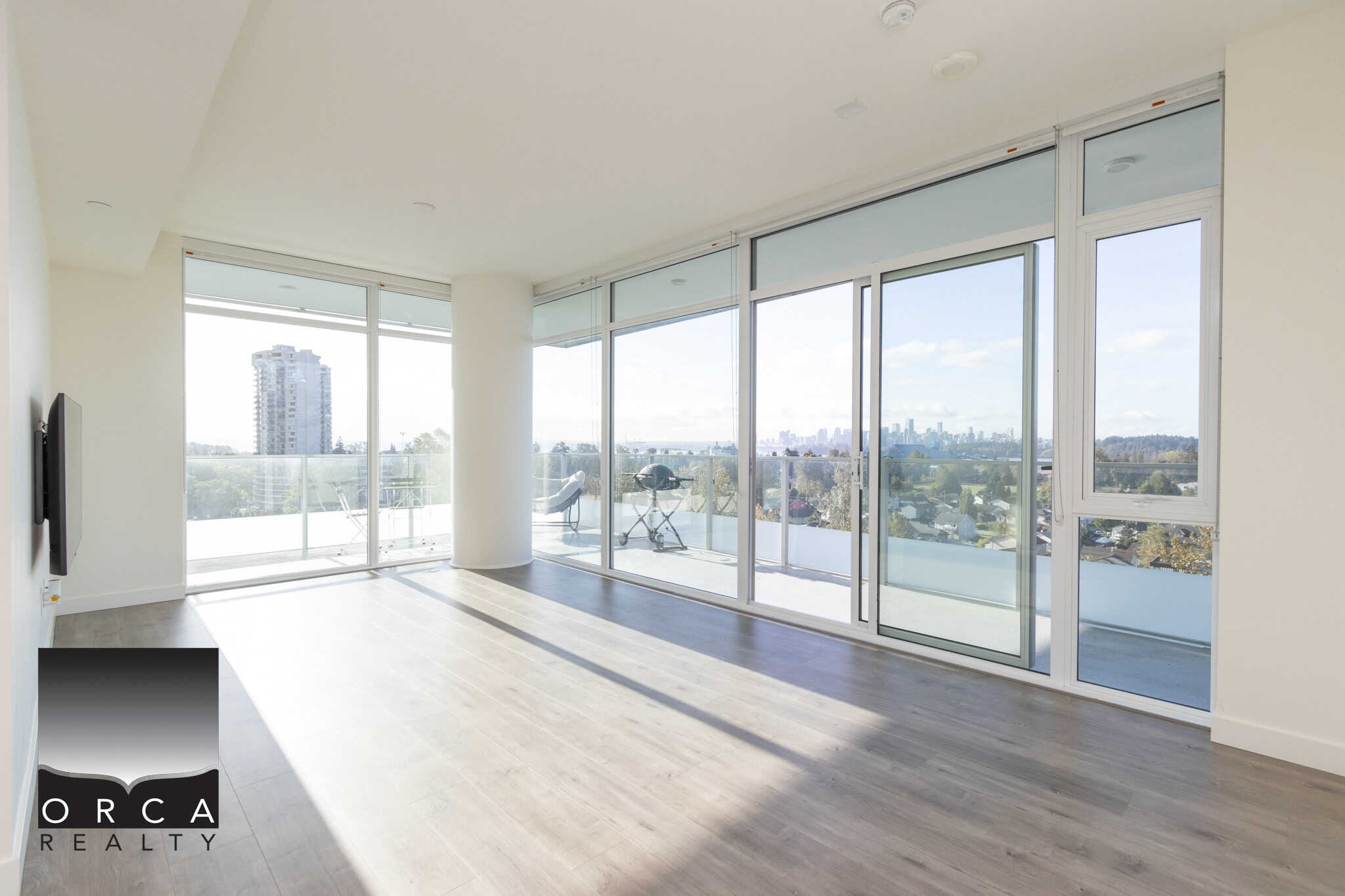 Bright modern living room with floor-to-ceiling glass sliding doors and balcony views, showcasing Vancouver skyline, perfect for Toronto downtown listings and real estate marketing.