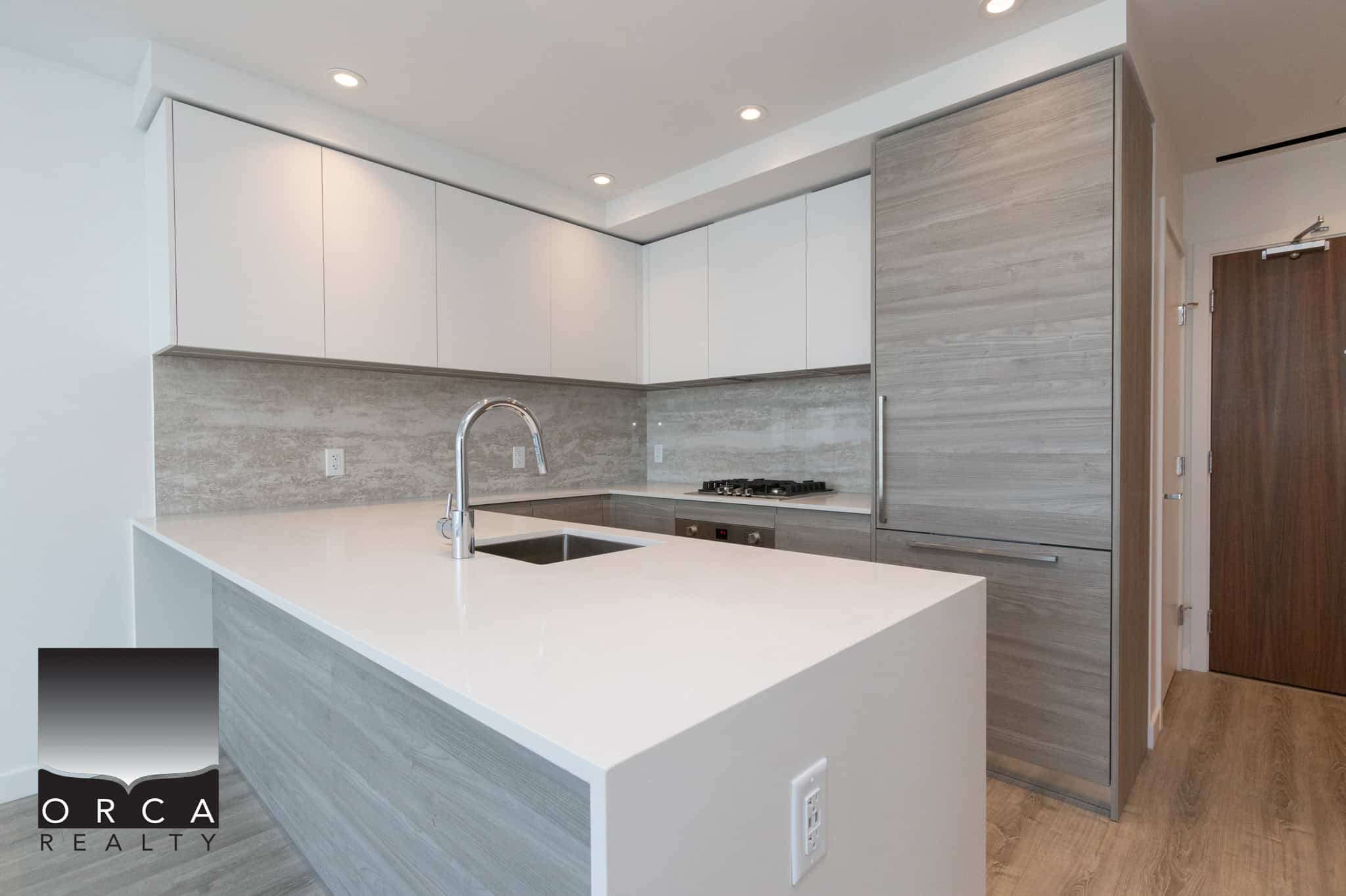 3 Modern kitchen with sleek white cabinetry, grey wood accents, and stainless steel appliances, perfect for Vancouver Island real estate buyers.