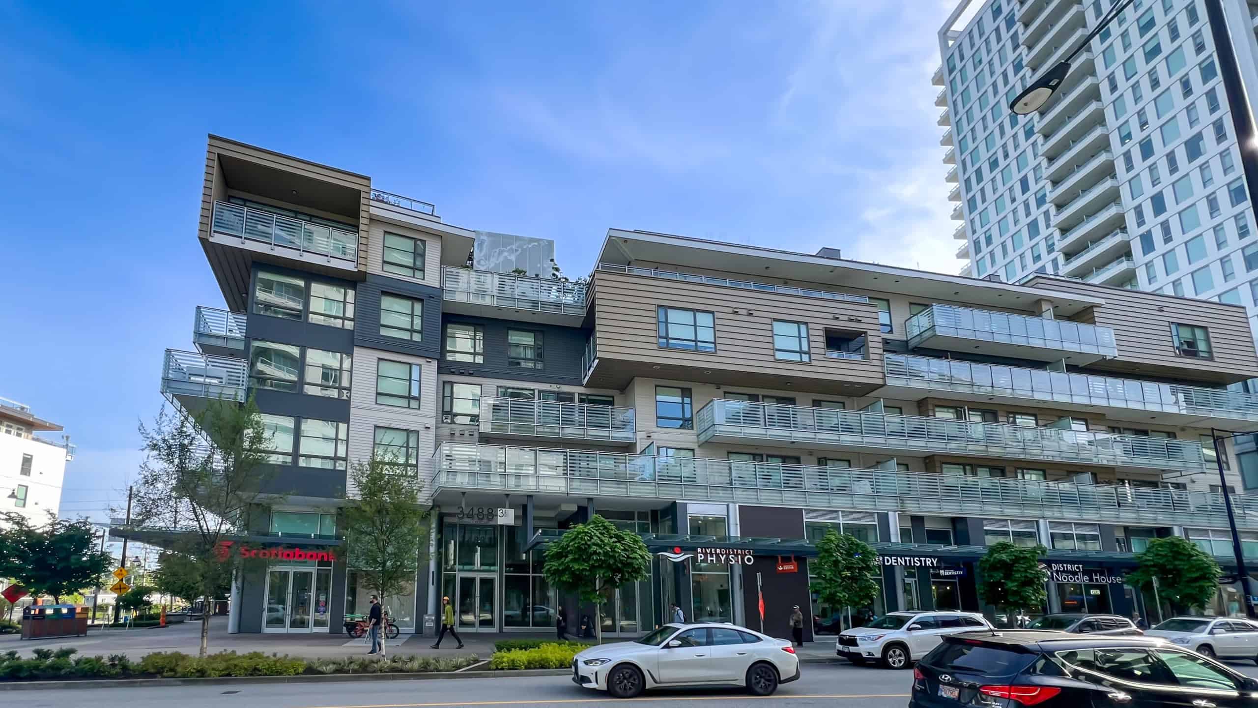 Contemporary mixed-use residential and commercial building in Vancouver with retail stores, including a Scotiabank branch, office spaces, and modern apartments, showcasing urban luxury living.