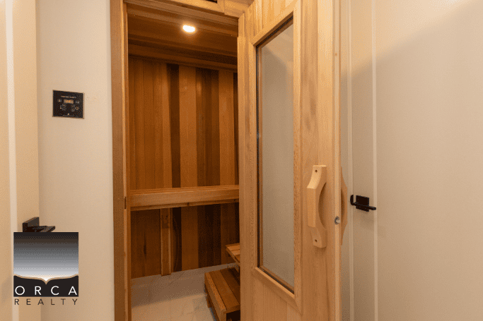 Luxurious wooden infrared sauna with glass door, ideal for relaxation and wellness at Orca Realty Inc. in Vancouver's real estate market.
