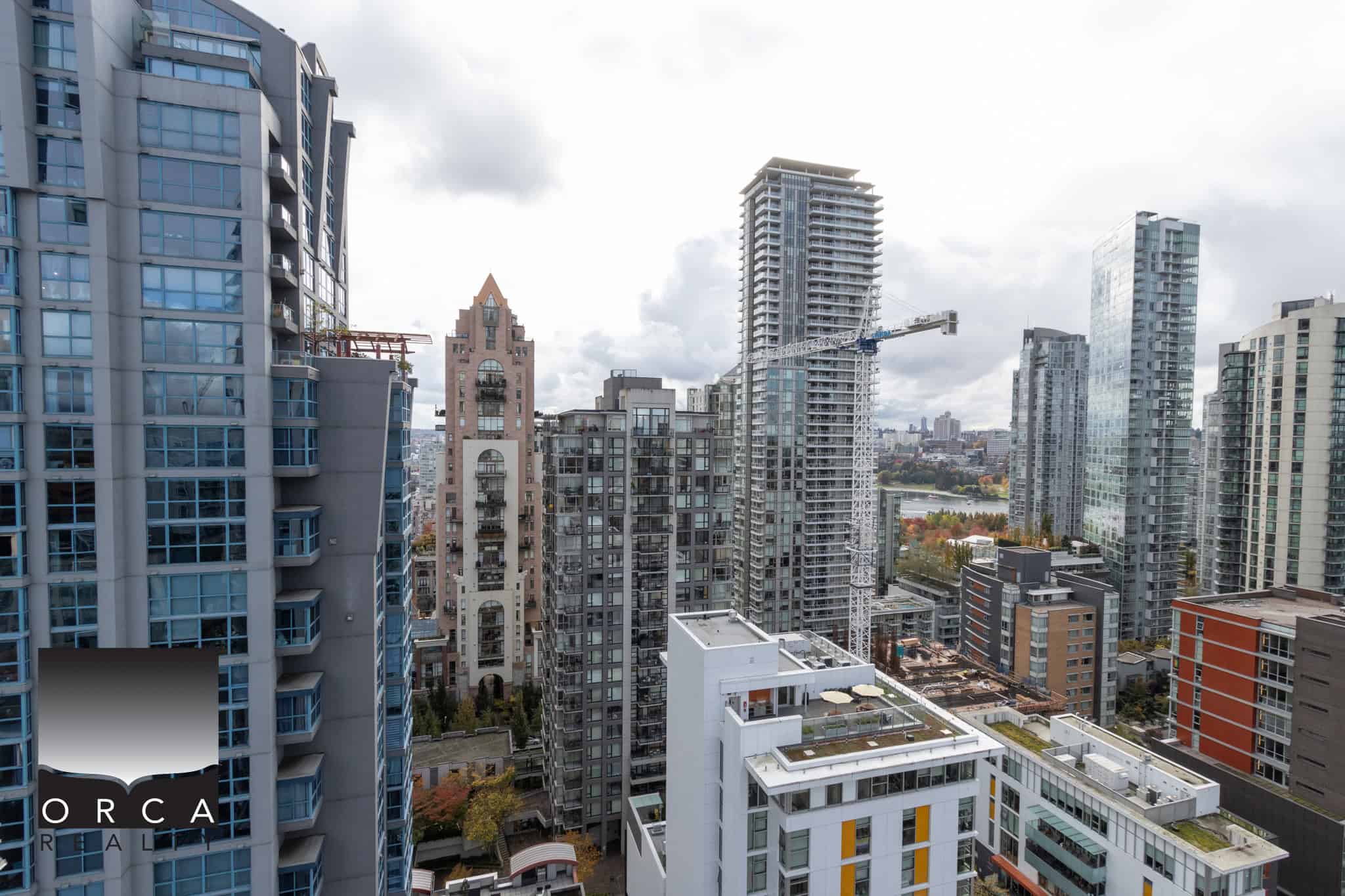 Breathtaking city skyline view featuring modern high-rise condos, with a construction crane indicating ongoing development in Vancouver, BC. Perfect for those interested in Vancouver real estate and property investments.