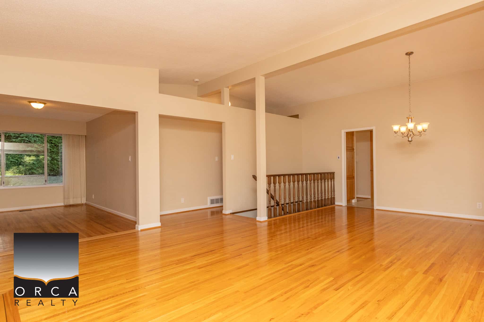Spacious open-concept living area with hardwood floors, neutral wall tones, and large windows in a family-friendly home for sale in Ontario.