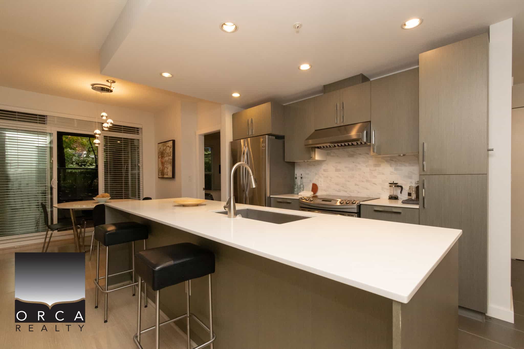 Modern kitchen with stainless steel appliances, white countertops, grey cabinets, and a spacious island, ideal for family cooking and entertaining in Vancouver.