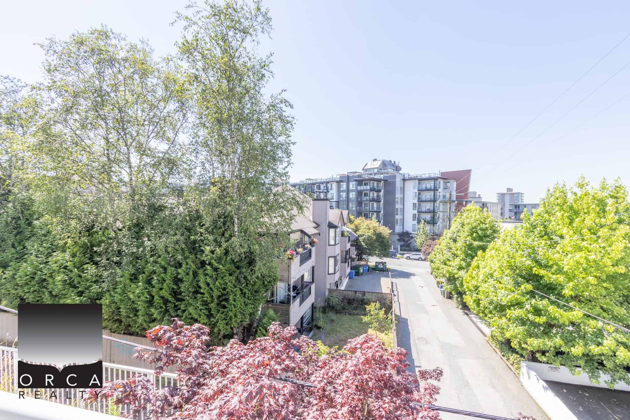 Vibrant neighbourhood with lush greenery and modern apartment buildings in Vancouver, BC, showcasing prime real estate and a welcoming community, ideal for homebuyers and investors.
