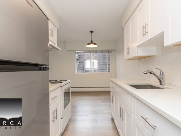 Bright white kitchen with modern cabinetry, stainless steel appliances, and ample counter space, ideal for Vancouver real estate buyers seeking contemporary homes.