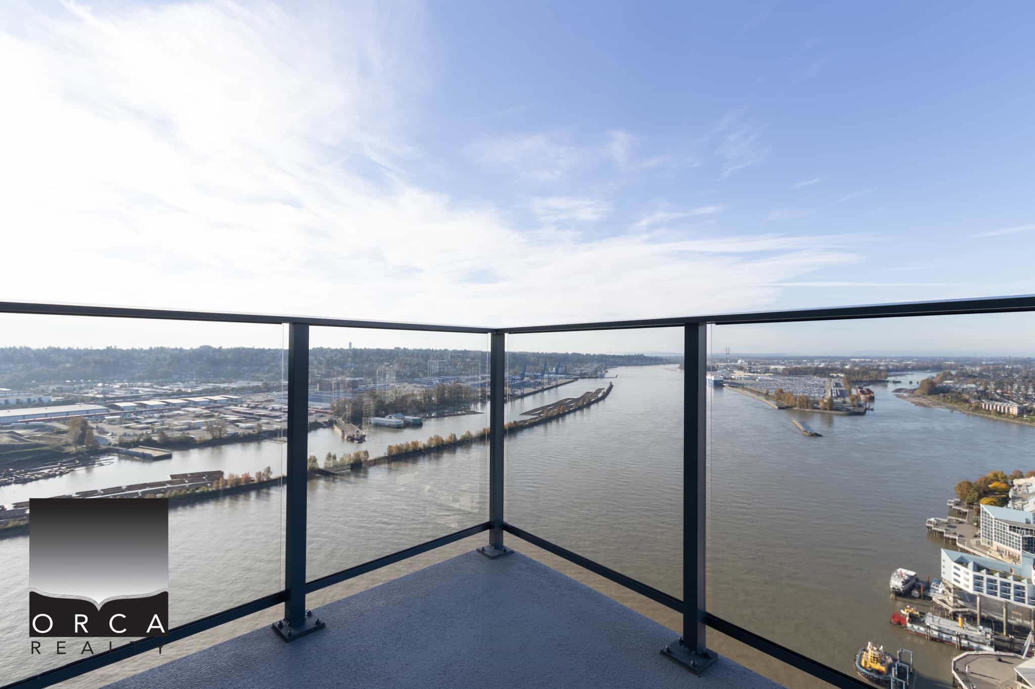 6 Stunning waterfront view from a high-rise balcony in Vancouver, British Columbia, showcasing the urban skyline, river, and distant mountains, ideal for Vancouver real estate and luxury condo listings.