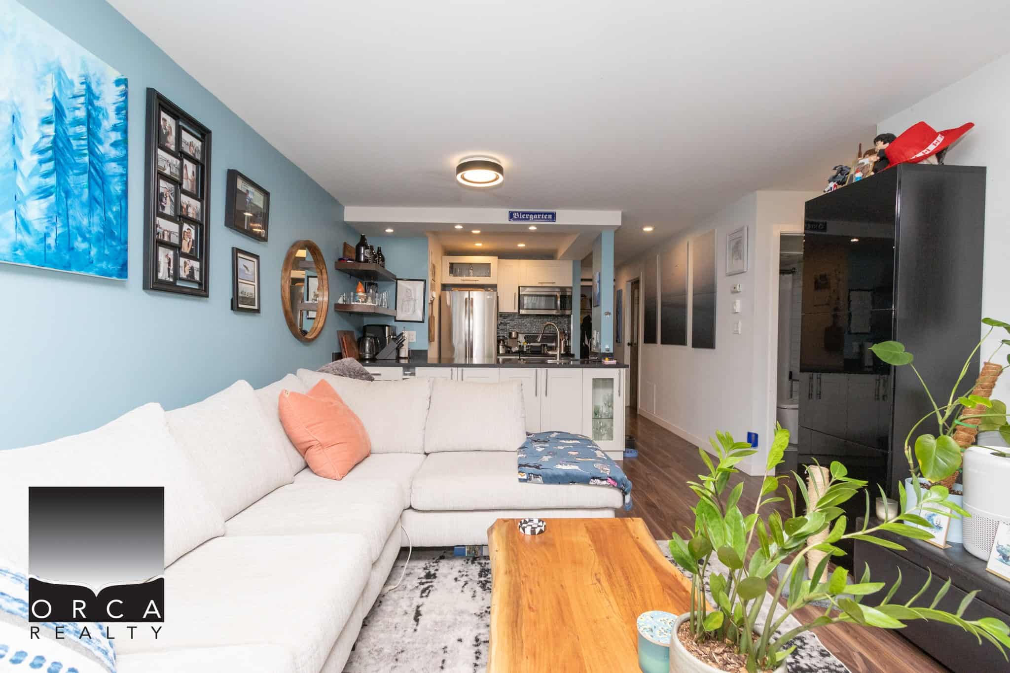 Cozy modern living room with open-concept kitchen, stylish decor, and natural light in Victoria, BC – perfect for homebuyers seeking contemporary residential real estate.