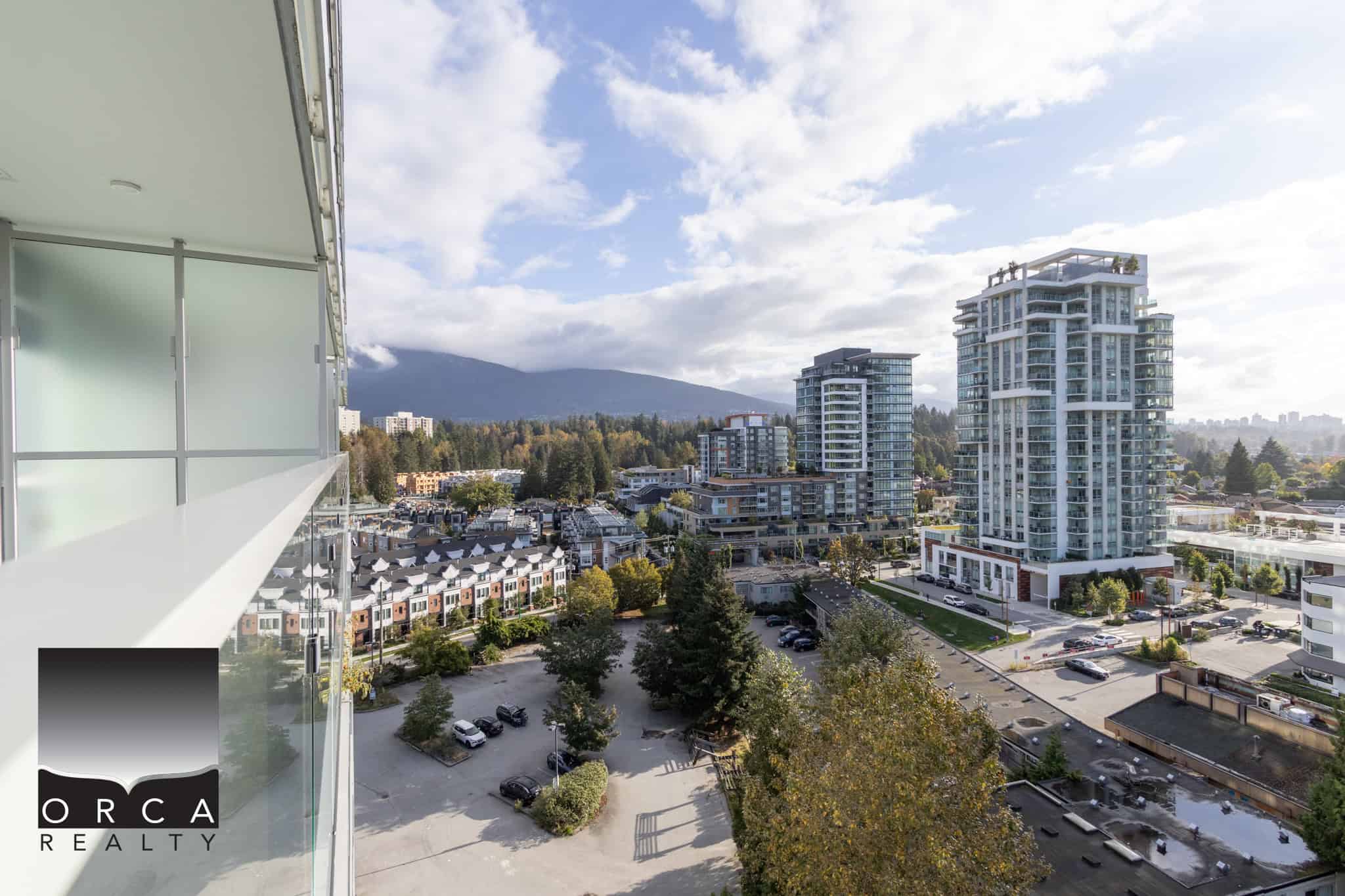 Panoramic view of downtown Vancouver, high-rise condos, and mountains in the background from an Orca Realty Inc. listing. Experience city living with stunning natural scenery.