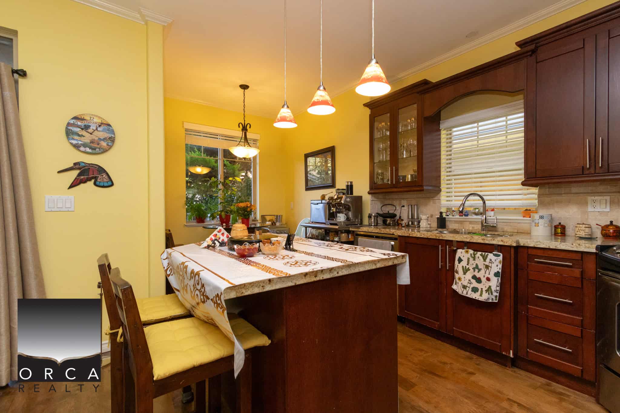 7 Cozy kitchen with dark wood cabinets, granite countertops, pendant lighting, and a breakfast island, perfect for family gatherings and home cooking. Bright, welcoming space with large windows and stylish decor.