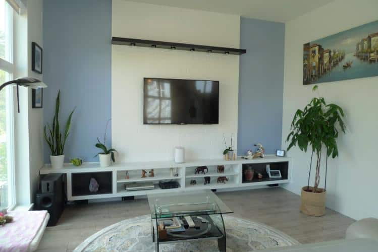 Bright modern living room with wall-mounted TV, minimalist decor, and ample natural light, showcasing contemporary home interior design.