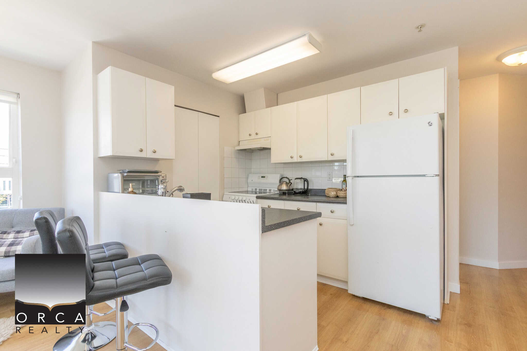 Bright white kitchen with modern appliances, updated cabinetry, and an open layout ideal for Vancouver Island real estate and property investment opportunities.