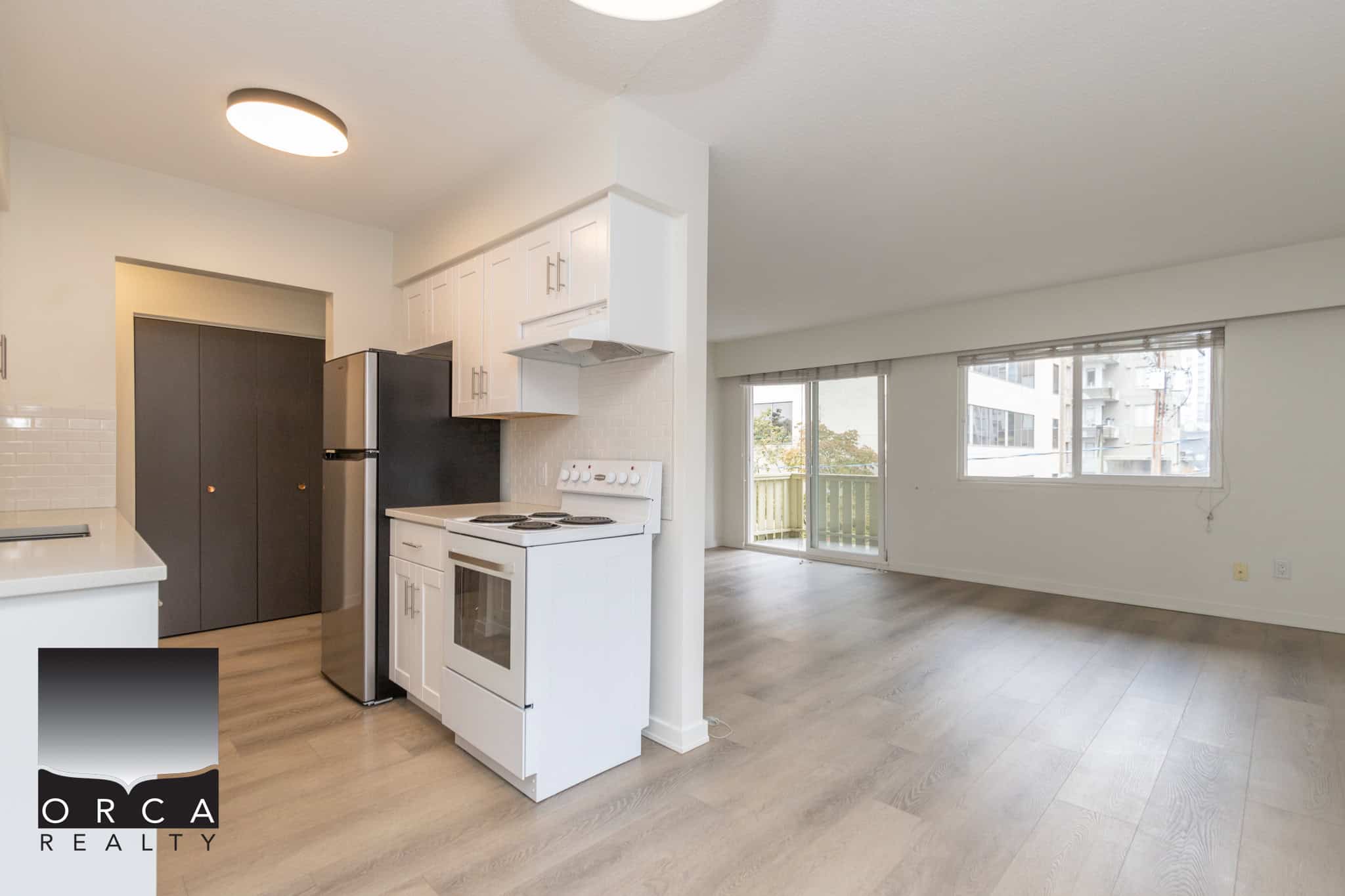 Bright open-concept apartment with modern kitchen, large windows, and balcony access in Vancouver. Perfect for homebuyers or renters seeking urban living in a vibrant neighbourhood.