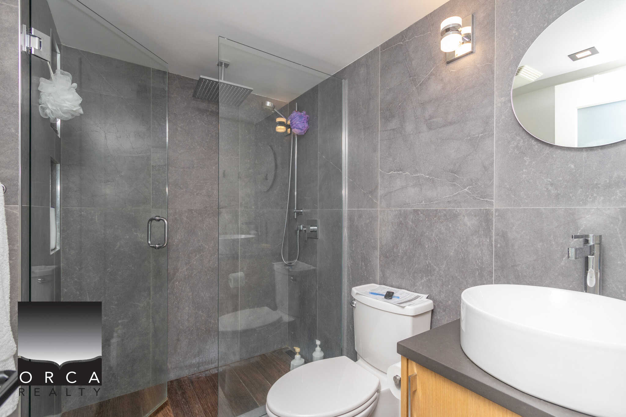 9 Modern grey-tile bathroom with glass shower enclosure and sleek fixtures, offering a luxurious and contemporary space ideal for Vancouver properties.