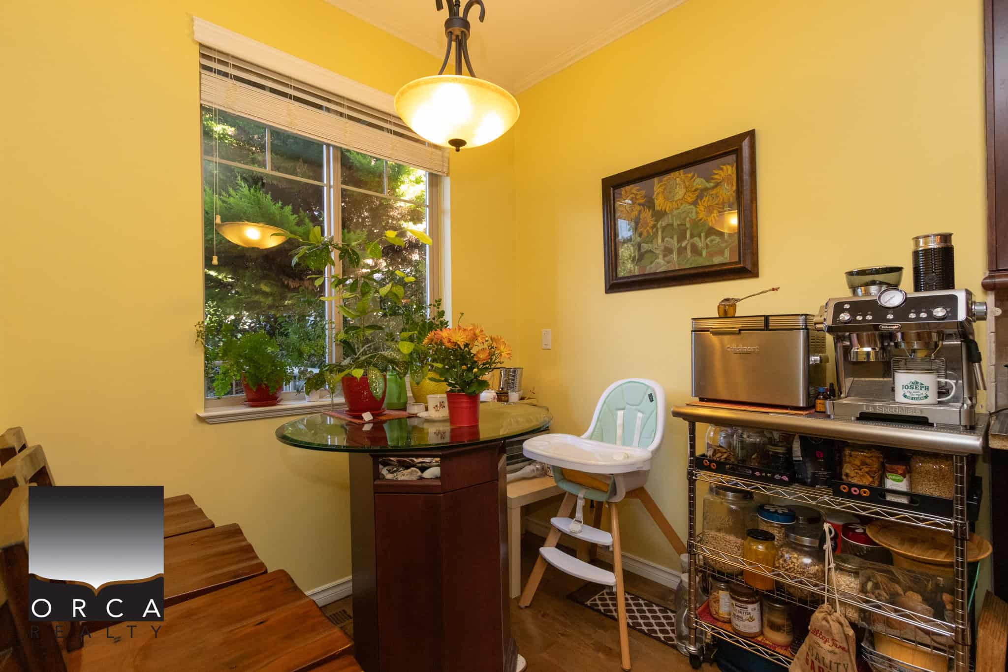 9 Bright yellow kitchen with potted plants, a glass dining table, and a coffee station, ideal for Vancouver real estate buyers.