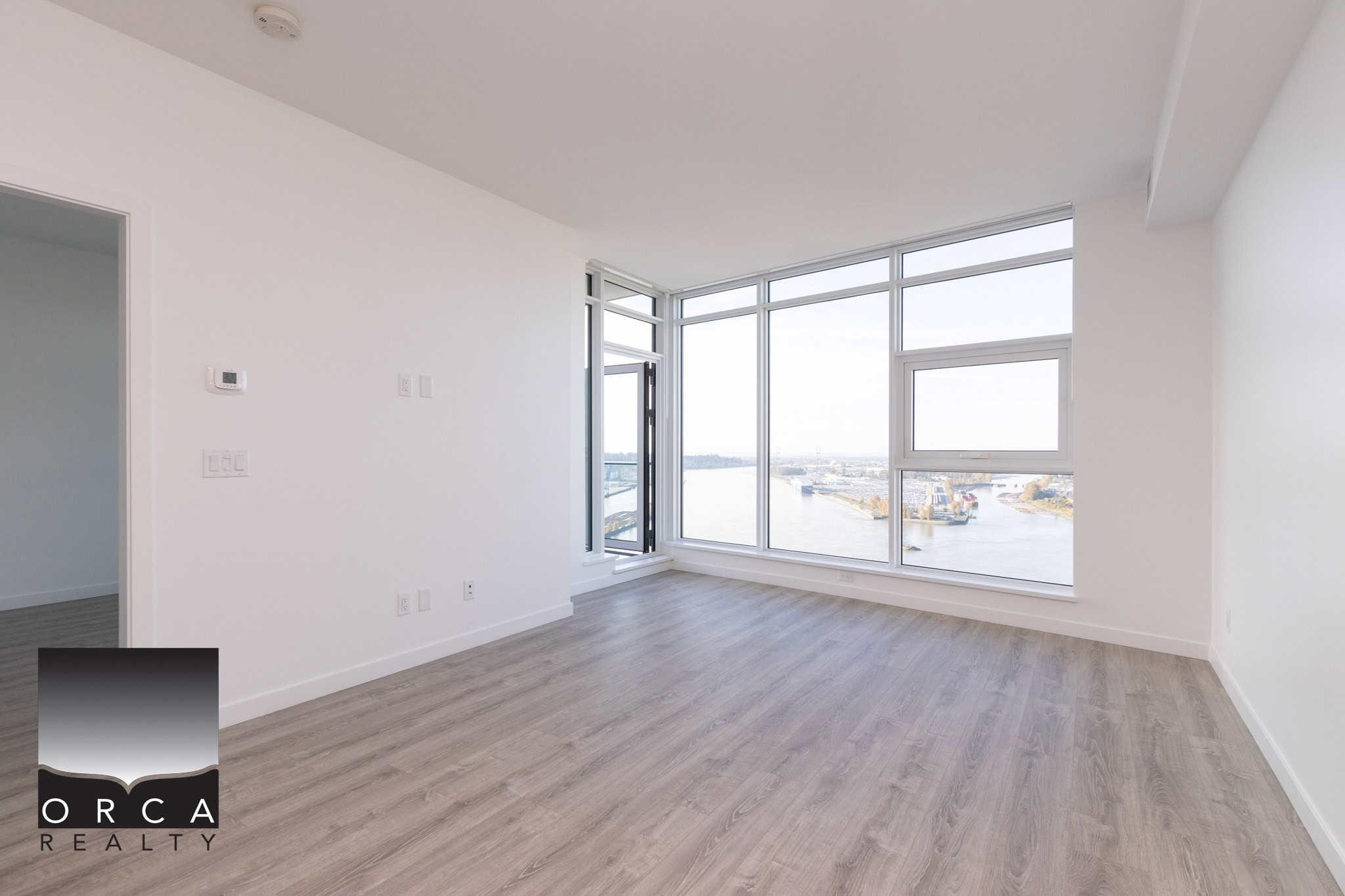 9 Bright living room with large windows showcasing river views, modern interior design, and spacious layout, ideal for Vancouver real estate buyers seeking waterfront apartments.