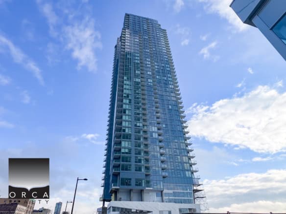 Modern high-rise condominium building in downtown Vancouver with glass exterior, spacious balconies, and panoramic city views, ideal for luxury urban living and real estate investment.