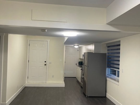 Bright, modern kitchen within a spacious home for sale by Orca Realty Inc. featuring white cabinetry, stainless steel appliances, and dark hardwood flooring, ideal for comfortable living in Victoria, BC.