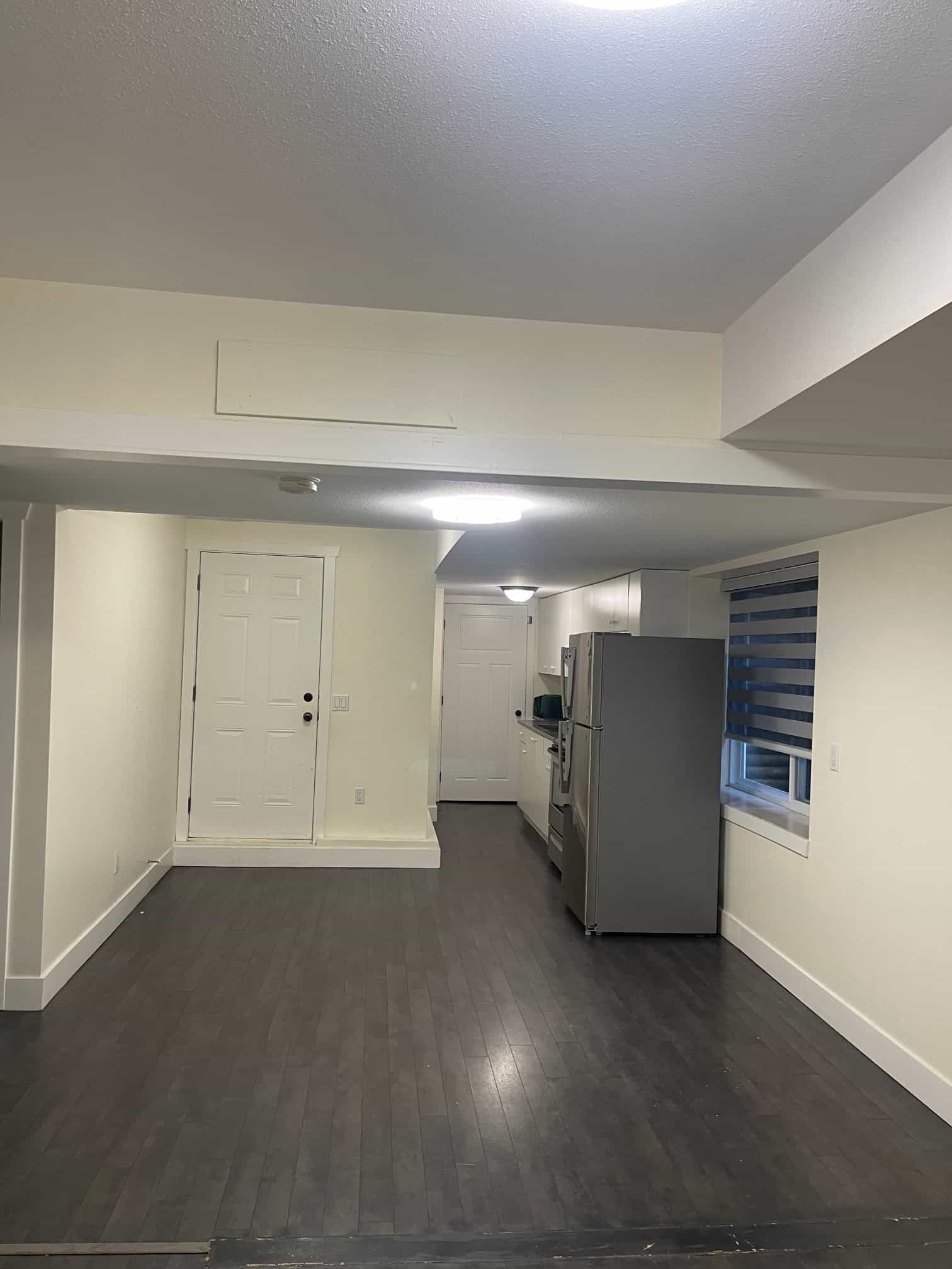 Bright, modern kitchen within a spacious home for sale by Orca Realty Inc. featuring white cabinetry, stainless steel appliances, and dark hardwood flooring, ideal for comfortable living in Victoria, BC.