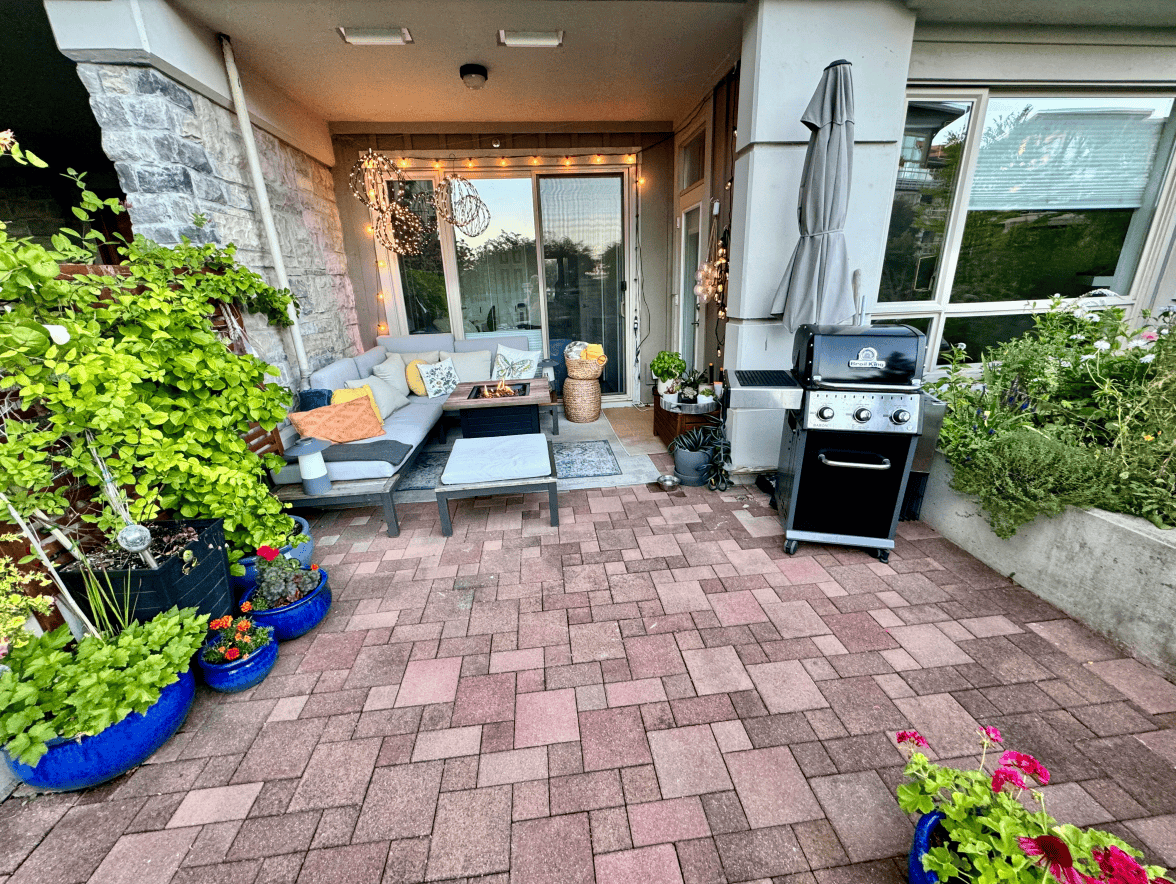 Lush outdoor patio space with comfortable seating, vibrant plants in decorative pots, and a BBQ grill, perfect for relaxing or entertaining in Vancouver’s desirable real estate market.