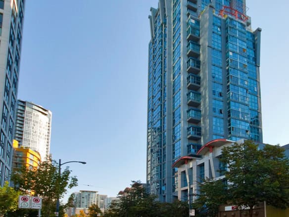 Office building with glass facade in Vancouver, BC, showcasing modern high-rise architecture perfect for real estate investments or residential condos, offered by Orca Realty Inc.