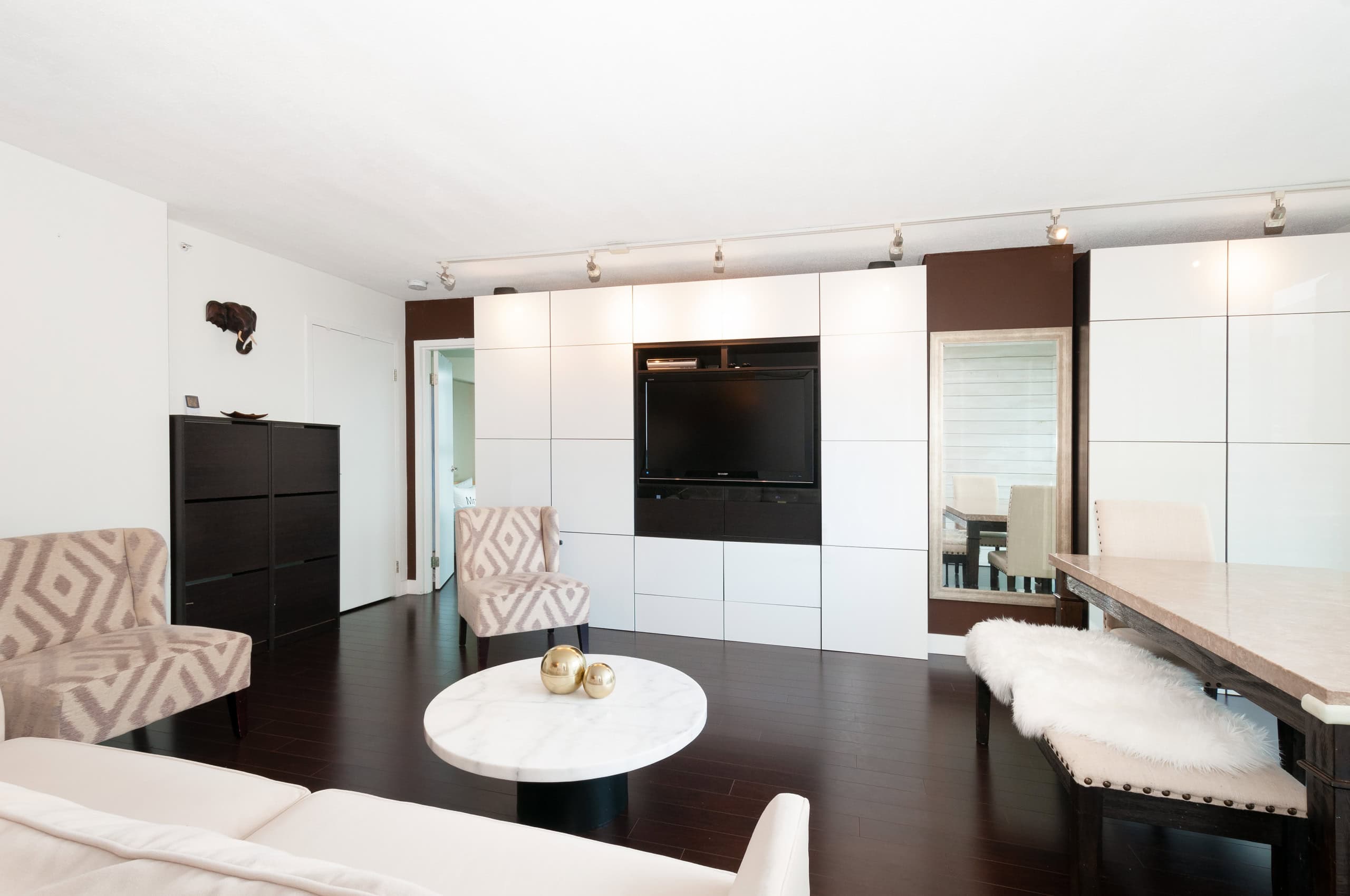 007 Contemporary living room with modern decor, wall-mounted TV, and cozy seating, ideal for Vancouver real estate and property viewing through Orca Realty Inc.