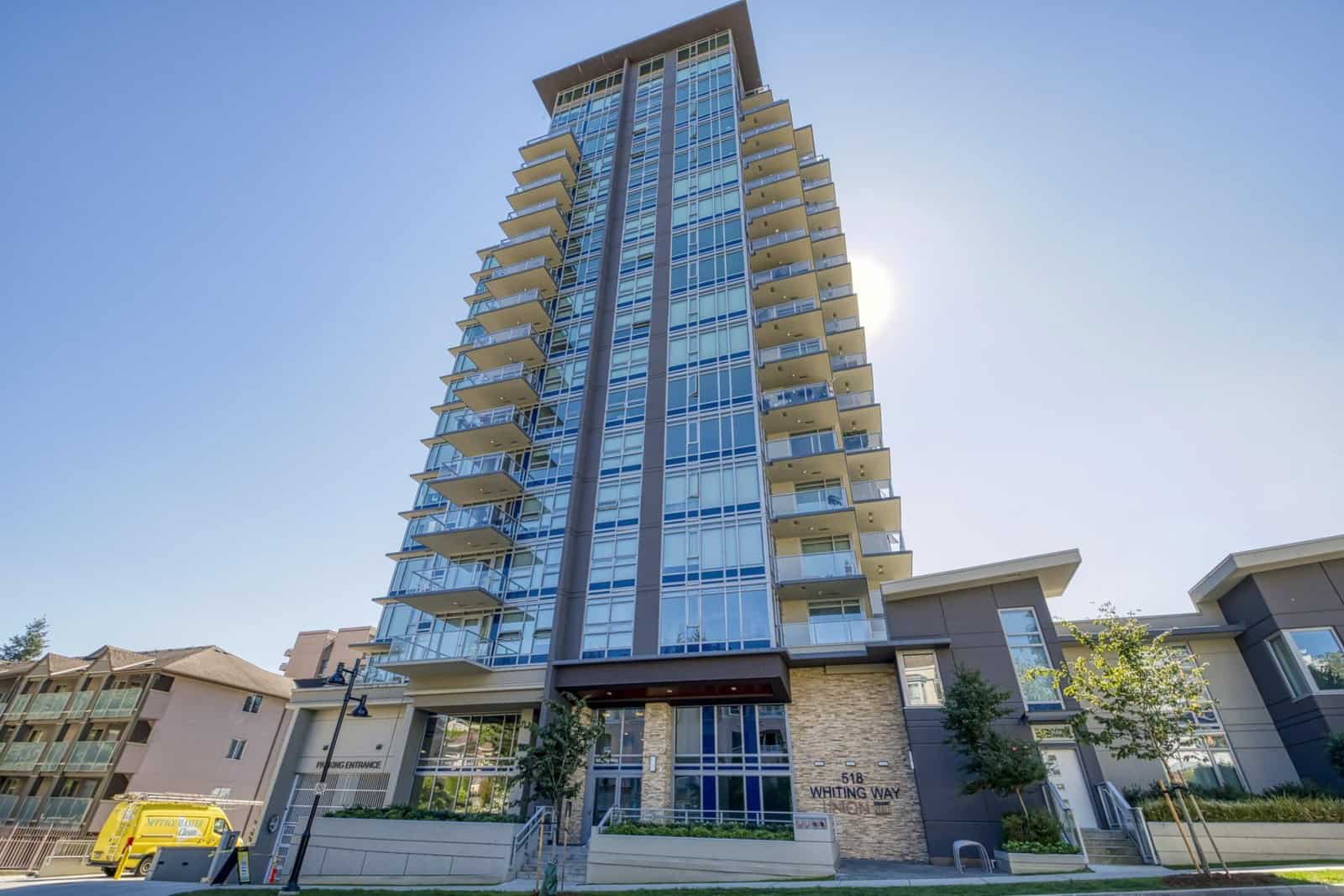 Modern high-rise residential building with glass balconies in Vancouver, BC.