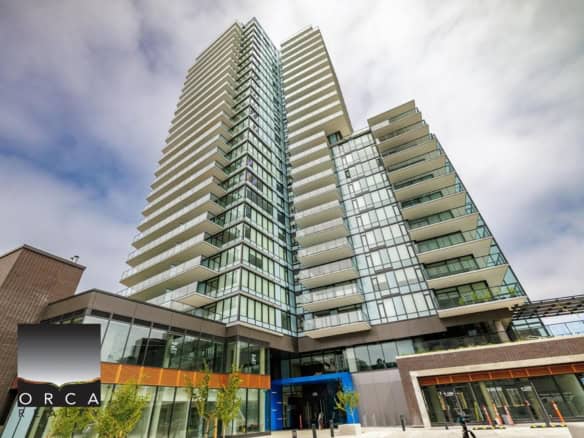 Contemporary high-rise condo building with glass façade, multiple balconies, located in Vancouver, BC, showcasing modern luxury real estate in a prime urban location.
