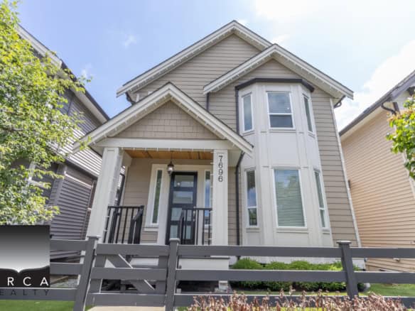 Contemporary two-story residential home with modern architecture, beige siding, bay windows, front porch, and landscaped yard, showcasing prime real estate near Orca Realty in a desirable neighbourhood.