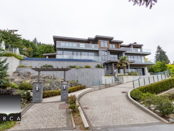Modern luxury waterfront residence with expansive glass windows, spacious balconies, and landscaped exterior, located in a sought-after neighbourhood.